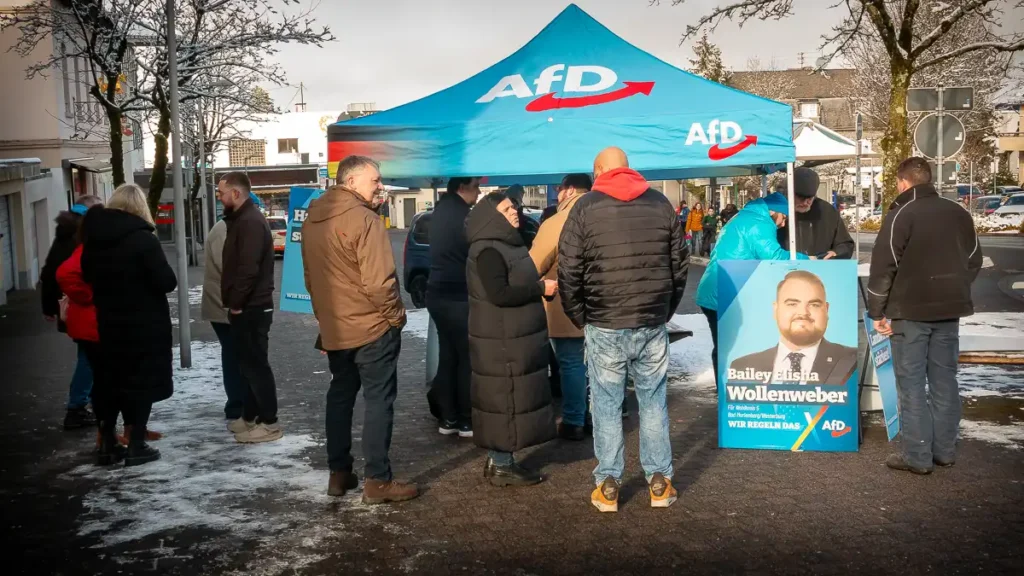 Infostand der AfD-Westerwald mit einem blauem Zelt und vielen interessierten Bürger.Die Stimmung ist winterlich mit einigem Schnee-Flecken